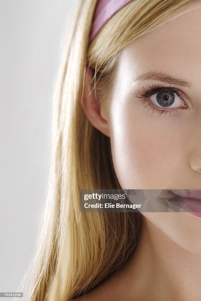 Portrait of a young woman looking at the camera, indoors (studio)