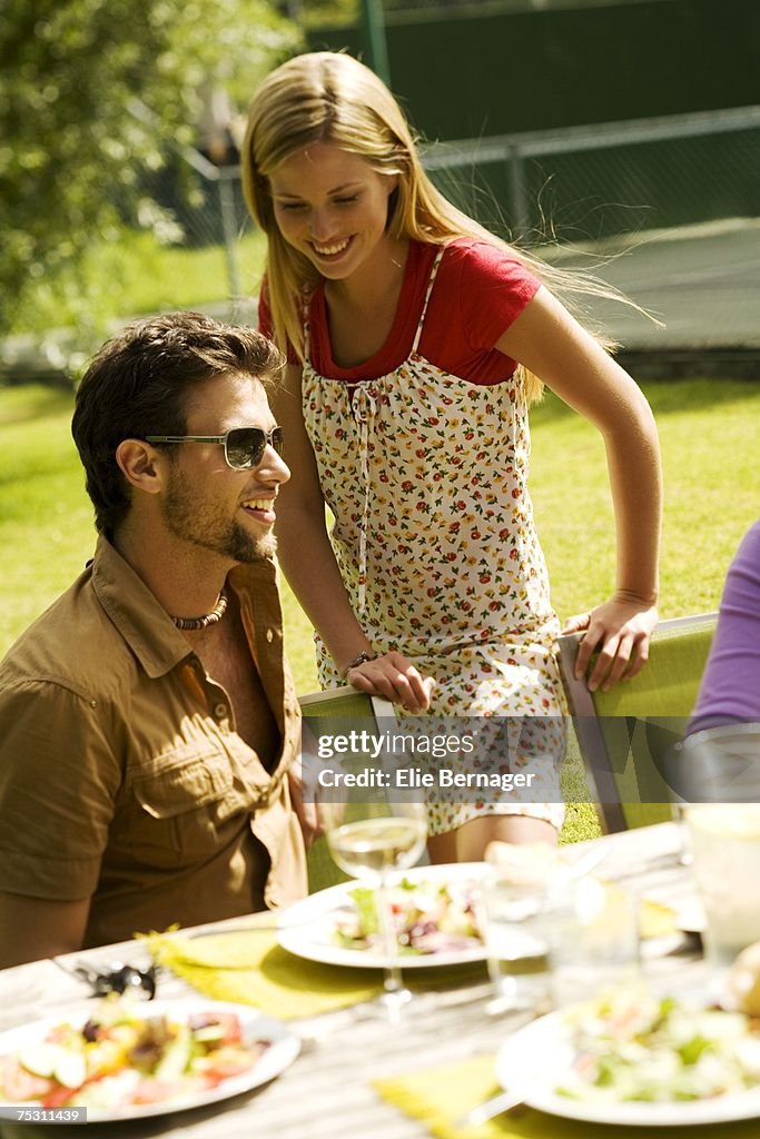 Young smiling couple at garden table