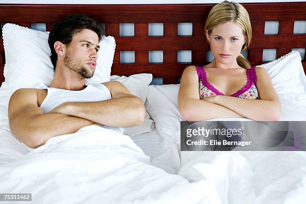 young couple in bed, arms crossed - straight black hair stock pictures, royalty-free photos & images