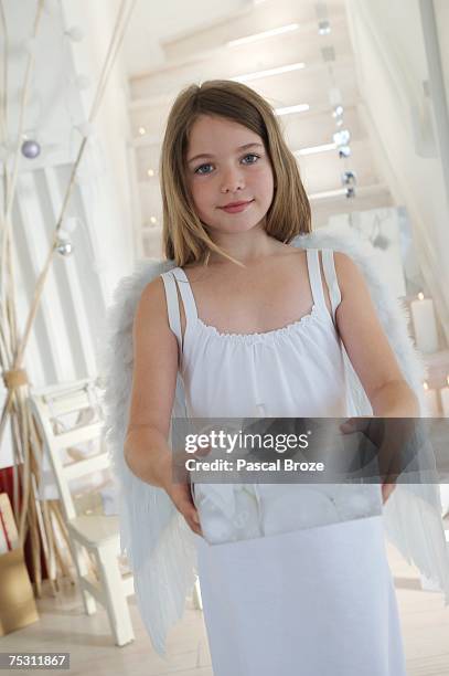 little girl holding a christmas present, indoors - kerstkind stockfoto's en -beelden