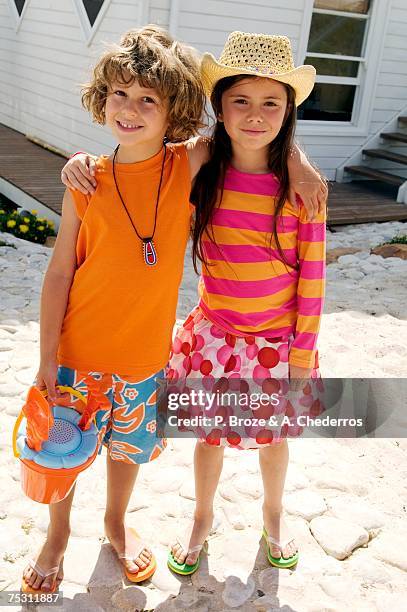 little boy and little girl looking at the camera, in front of a house, outdoors - girls with short skirts photos et images de collection