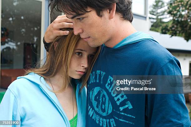 teenage boy consoling teenage girl - b��ro stock-fotos und bilder