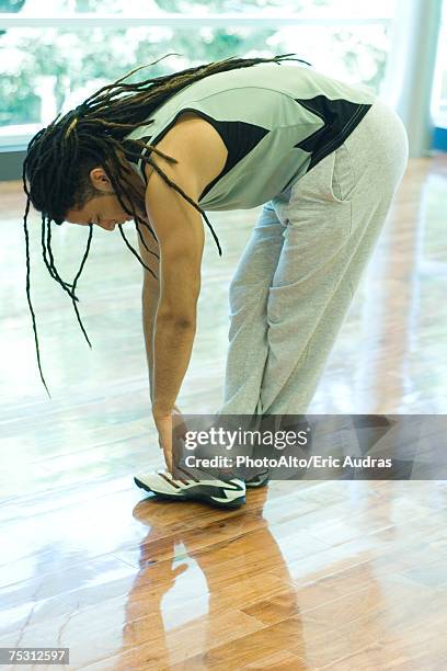 man doing standing forward bend, full length - legs crossed at ankle stock pictures, royalty-free photos & images