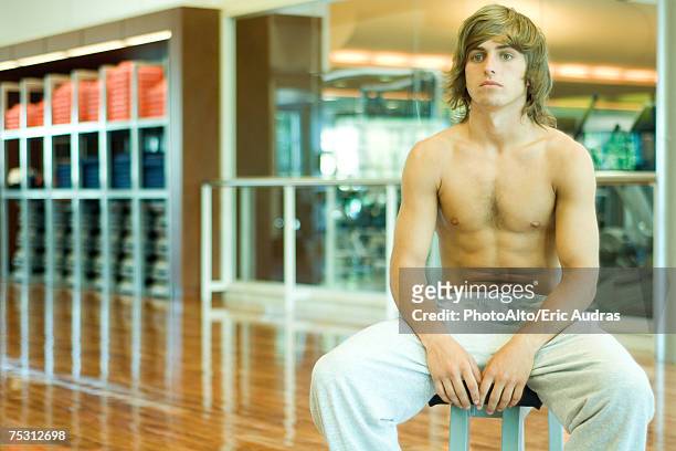 young man sitting on stool, bare-chested - hairy chest man stock pictures, royalty-free photos & images