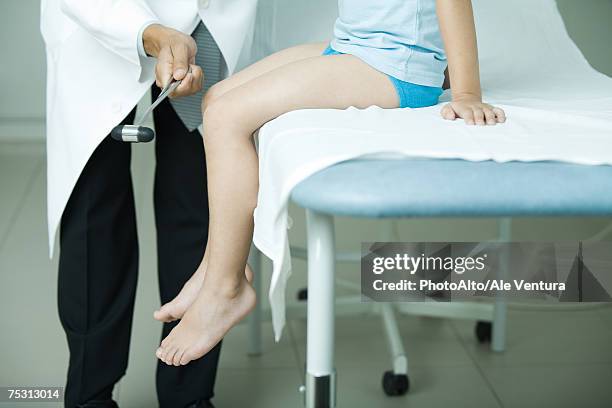 doctor checking boy's reflexes with reflex hammer - martelo de reflexo - fotografias e filmes do acervo