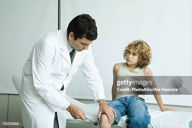 doctor checking boy's reflexes - reflexhammare bildbanksfoton och bilder