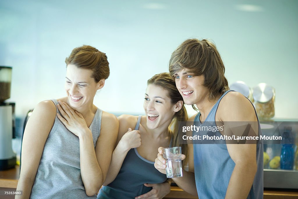 Young adults in exercise clothing, taking break in health club cafeteria