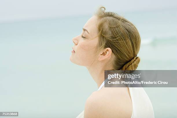 young woman, head and shoulders, side view, sea in background - natural blonde fotografías e imágenes de stock