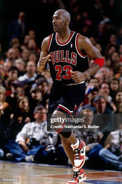 Michael Jordan of the Chicago Bulls jogs up court wearing his original Nike sneakers against the New York Knicks during his final game at Madison...