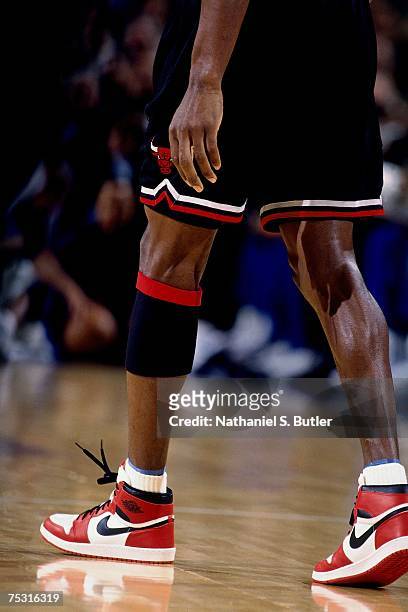 Michael Jordan of the Chicago Bulls walks up court wearing his original Nike sneakers against the New York Knicks during his final game at Madison...