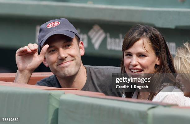 Actors Ben Affleck and Jennifer Garner smile while next to the Boston Red Sox dugout prior to the start of their baseball game against the New York...