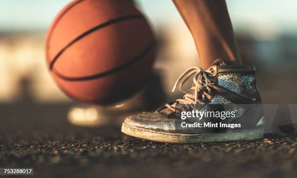 close up of a basketball bouncing near a persons feet. - basketball close up stock-fotos und bilder