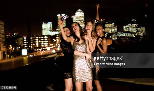 group of young women standing on a rooftop posing for a photograph. - vestito da sera femminile foto e immagini stock