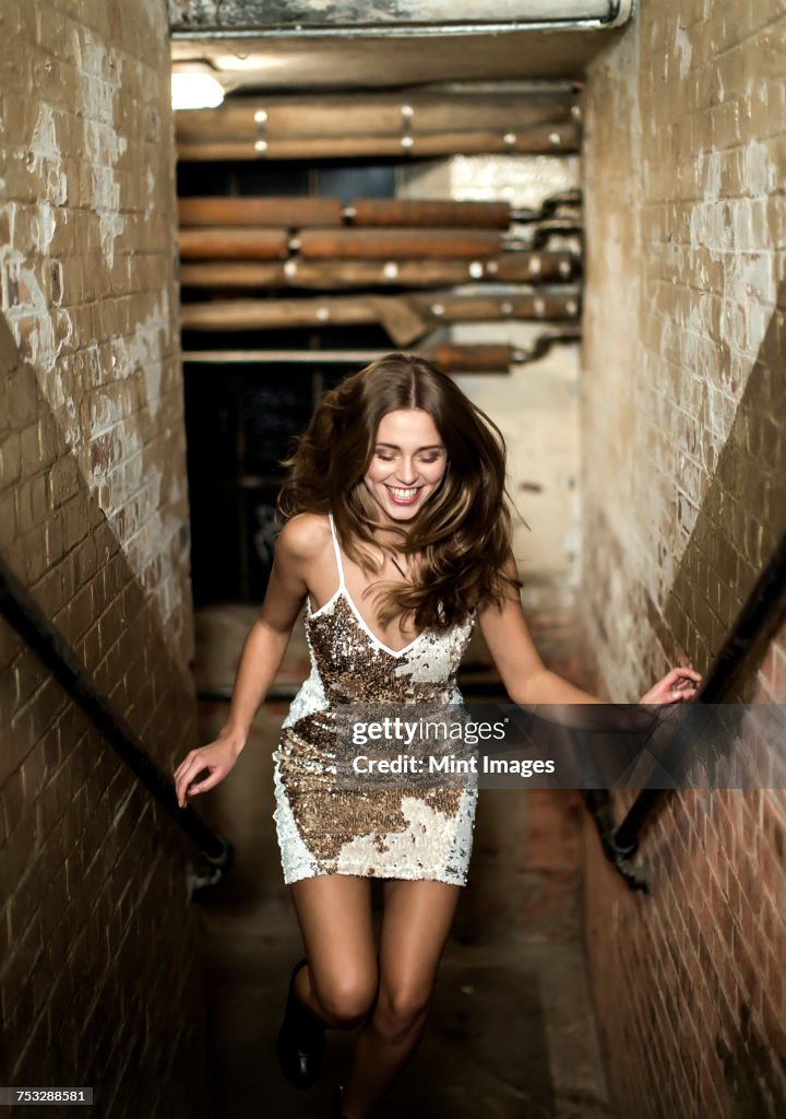 Young woman running up stairs.