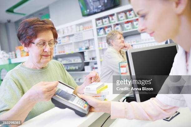 customer paying by credit card at drug store. rzeszow, poland - anna of poland fotografías e imágenes de stock