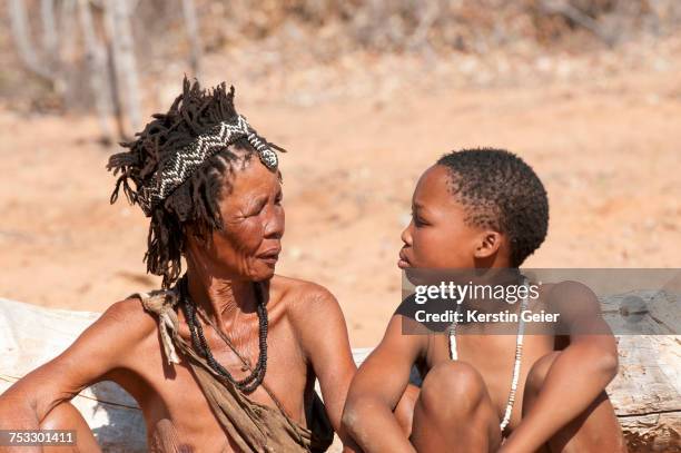 adolescent san (bushman) girl looking in grandmothers eyes. grashoek, bushmanland , namibia - kalahari desert stock pictures, royalty-free photos & images