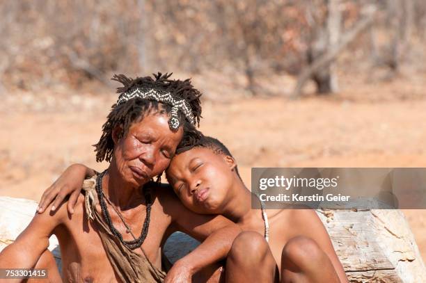 adolescent san (bushman) girl leaning against grandmother. grashoek, bushmanland , namibia - bushmen ストックフォトと画像