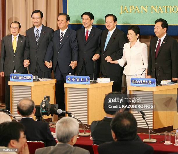 Japan's ruling and opposition party leaders, , shake hands each other after a debate for the upcoming Upper House poll at Japan National Press Club...