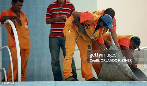 Rio de Janeiro, BRAZIL: Workers remove the carpet of the diving platform due to claims made by the athletes 11 July 2007, at the Maria Lenk Aquatic...