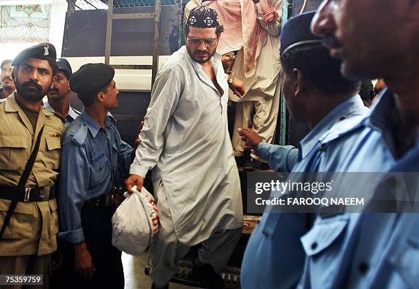 Detained Pakistani religious students of the Red Mosque come out of a police van as they arrive from the Adiala jail, where they were locked...