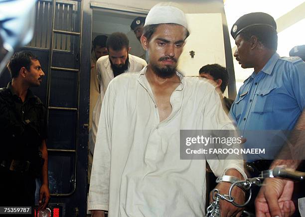 Detained Pakistani religious students of the Red Mosque come out of a police van as they arrive from the Adiala jail, where they were locked...