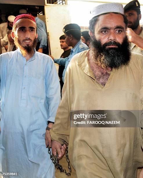 Detained Pakistani religious students of the Red Mosque come out of a police van as they arrive from the Adiala jail, where they were locked...