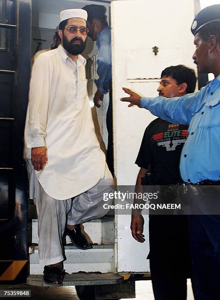 Detained Pakistani religious students of the Red Mosque come out of a police van as they arrive from the Adiala jail, where they were locked...