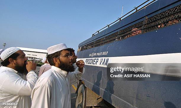 Relatives of Pakistani religious students of the Red Mosque talk with detained students sitting in a prisoner van as they arrive from the Adiala...