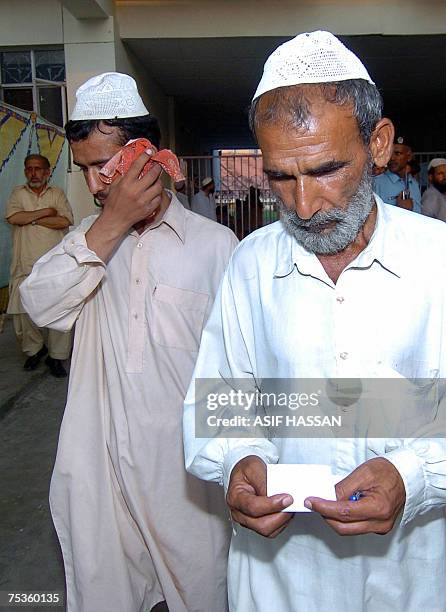 Freed Pakistani religious student of the Red Mosque weeps as he walks with his father, following his release from the Adiala jail, where he was...