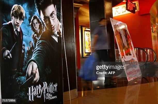 An Indian pedestrian walks past a poster advertising the latest film featuting the character Harry Potter at a cinema in Mumbai, 12 July 2007. Movie...