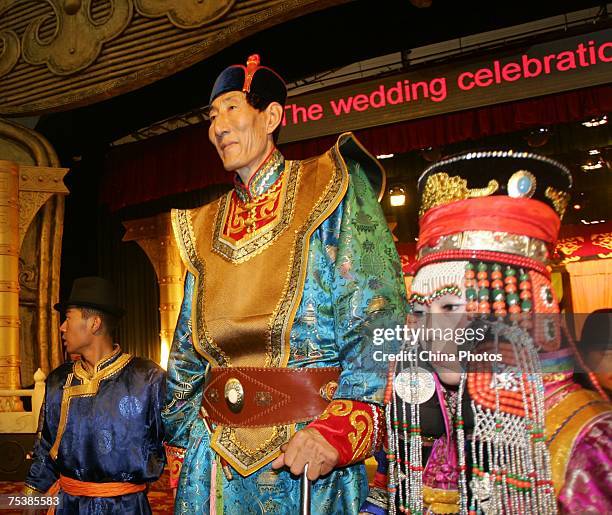 The world's tallest man Bao Xishun and his bride Xia Shujuan attend their traditional Mongolian wedding ceremony at Genghis Khan's Mausoleum on July...