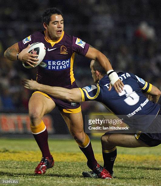 Corey Parker of the Broncos breaks the tackle of Scott Minto of the Cowboys during the round 18 NRL match between the North Queensland Cowboys and...