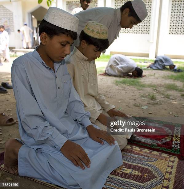 Pakistani boys pray at a local mosque during Friday prayers July 13 in Islamabad, Pakistan. Government reports indicate that 1 policeman, 10 soldiers...