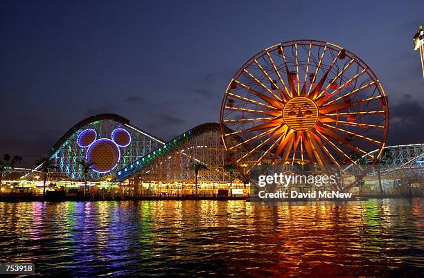 Coastal midway-type rides, including the California Sreamin'' roller coaster with the head of Mickey Mouse on it and the Sun Wheel ride , shine...