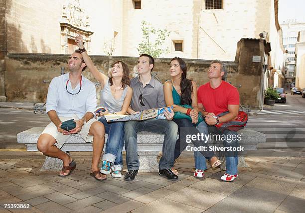 men and women sitting on bench, looking up - city map with points of interest stock pictures, royalty-free photos & images