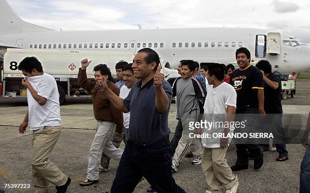 Indocumentados guatemaltecos gesticulan cuando caminan por la rampa de la Fuerza Aerea Guatemalteca en Ciudad de Guatemala, luego de ser deportados...