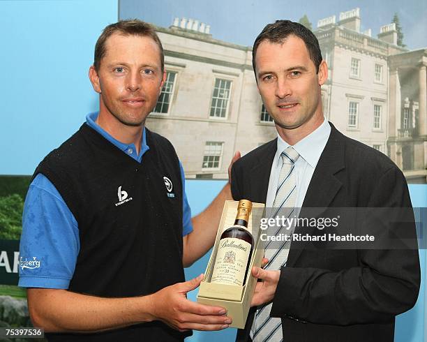 Soren Hansen of Denmark is presented with a 30 year old bottle of whisky for the lowest round of Thursday by Ballantine's International Marketing...