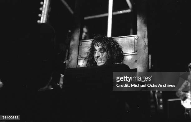 1970s: Rock star Alice Cooper's head in a guillotine for his outrageous stage show in June of 1977 in Los Angeles, California.