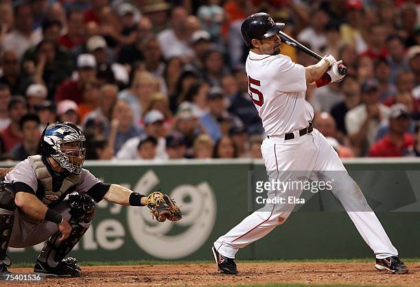 Mike Lowell of the Boston Red Sox hits a two RBI triple in the third inning against the Toronto Blue Jays on July 13, 2007 at Fenway Park in Boston,...