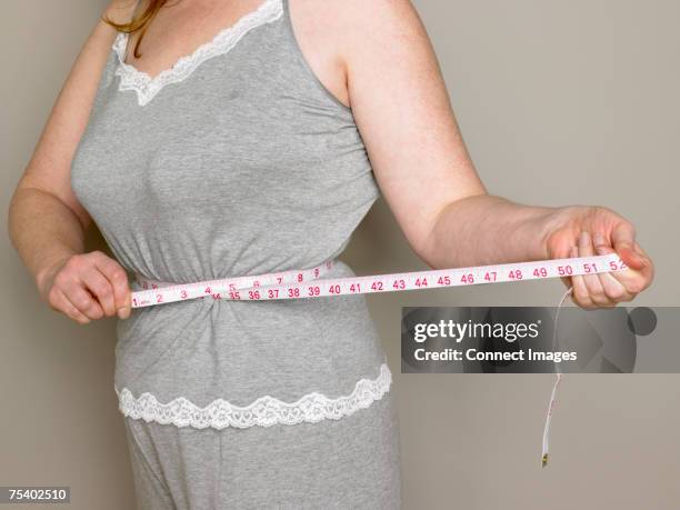 woman measuring her waist - waist stock pictures, royalty-free photos & images