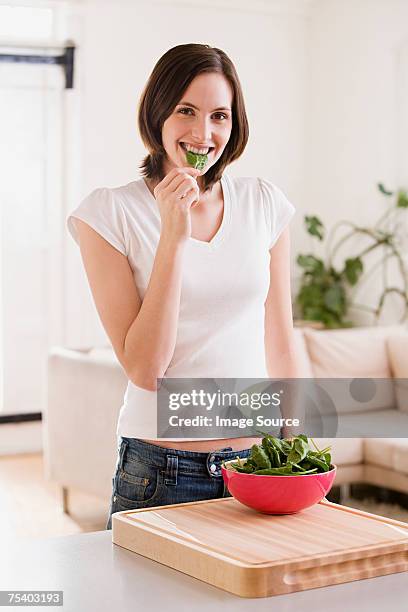 mujer comiendo espinacas - spinach fotografías e imágenes de stock