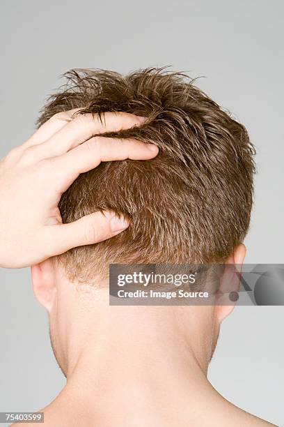 man with hand on head - back of head stockfoto's en -beelden