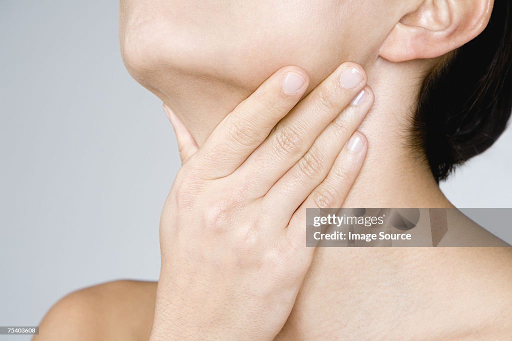 Mulher tocando o Pescoço