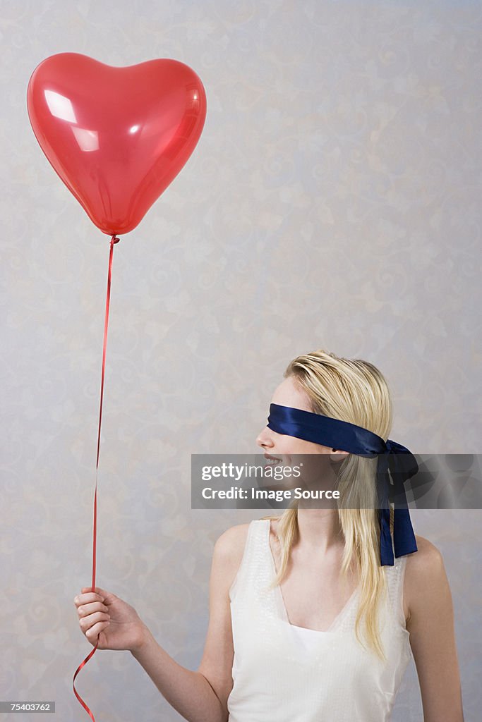 Blindfolded woman with balloon
