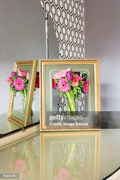 flowers in a picture frame - photo frame on mantle piece stockfoto's en -beelden
