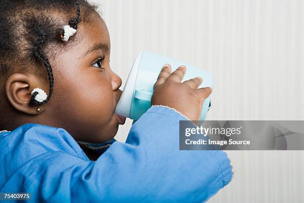 baby girl drinking from beaker - laboratoriumglas stockfoto's en -beelden
