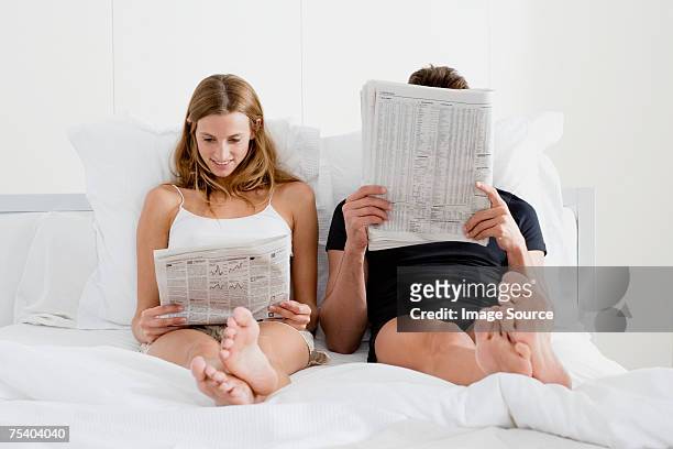 couple reading newspapers in bed - read and newspaper and bed stock pictures, royalty-free photos & images