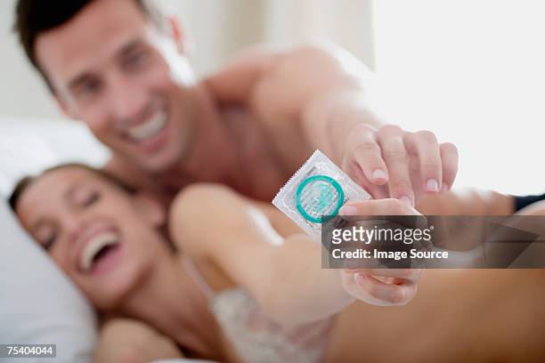couple with a condom - condom stock pictures, royalty-free photos & images
