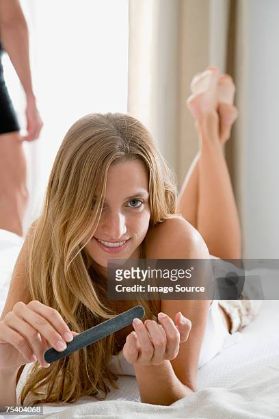 woman filing her nails - nail file stock pictures, royalty-free photos & images