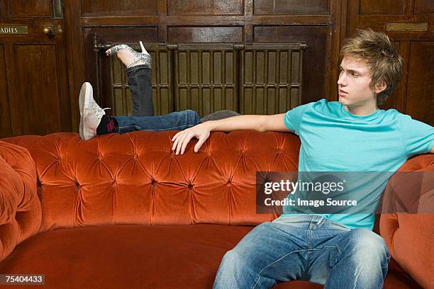 young couple behind sofa - teen soles stock pictures, royalty-free photos & images